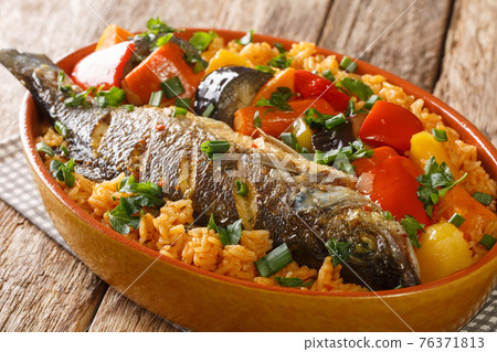 One-pot Thieboudienne Traditional West African Fish and Rice Dish with vegetables closeup in the dish. horizontal One-pot Thieboudienne Traditional West African Fish and Rice Dish with vegetables closeup in the dish. horizontal 76371813