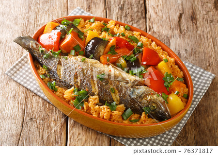 Senegalese food Thieboudienne cooked rice and fish with vegetables close-up in a dish. horizontal 76371817