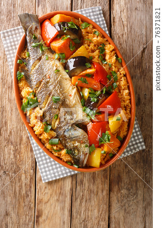 Thieboudienne Fish and Rice The National food of Senegal closeup in the dish. Vertical top view Thieboudienne Fish and Rice The National food of Senegal closeup in the dish. Vertical top view 76371821