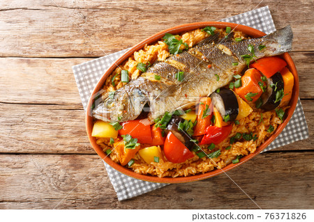 One-pot Thieboudienne Traditional West African Fish and Rice Dish with vegetables closeup in the dish. horizontal top view 76371826