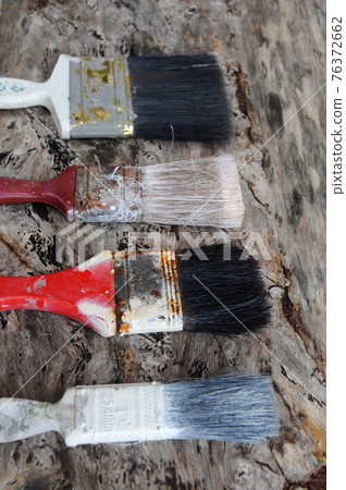 Old paint brush on old wood board. 76372662