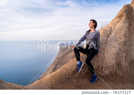 Woman looking on sunrise in the mountains 76373127