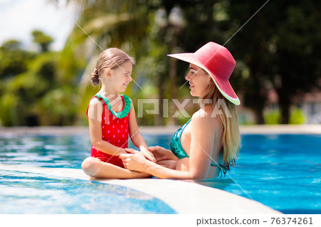 Mother, child at swimming pool. Mom and kid swim. 76374261