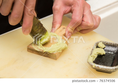 Hands of a man who grate wasabi Hands of a man who grate wasabi 76374506