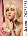 beauty portrait of a young beautiful blonde girl of Asian or Egyptian appearance on a pink solid background. 76374731