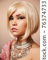 beauty portrait of a young beautiful blonde girl of Asian or Egyptian appearance on a pink solid background. 76374733