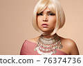 beauty portrait of a young beautiful blonde girl of Asian or Egyptian appearance on a pink solid background. 76374736
