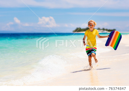 Kids playing on beach. Children play at sea. Kids playing on beach. Children play at sea. 76374847