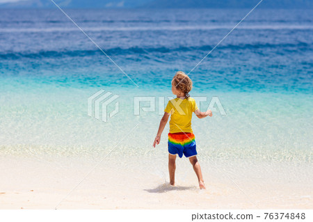 Kids playing on beach. Children play at sea. 76374848