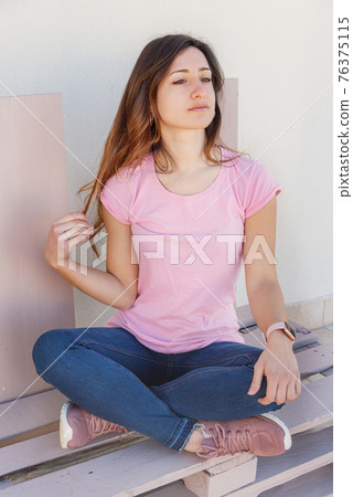 Young women sitting and touching her long hair 76375115