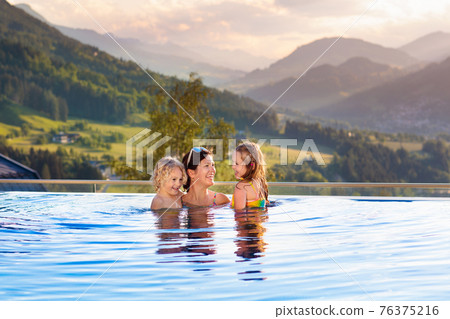 Family in swimming pool with mountain view 76375216