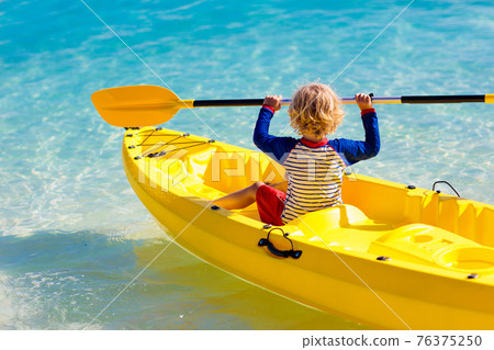 Kids kayaking in ocean. Family in kayak in tropical sea 76375250
