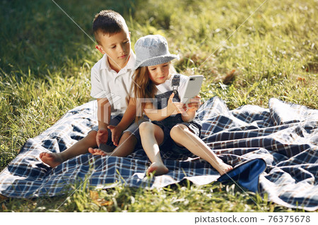 Cute little girl playing in a park with her friend Cute little girl playing in a park with her friend 76375678