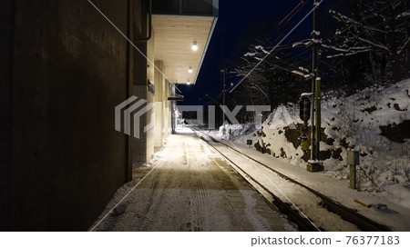 A night perspective of the waiting platform of a train station in northern Europe A night perspective of the waiting platform of a train station in northern Europe 76377183