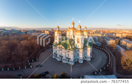 Aerial top view to St. Nicholas Naval Sea Cathedral in sunny day. Panorama of evening historical city center. Orthodox church located on banks of Kryukov and Griboyedov canal. Saint Petersburg. Russia Aerial top view to St. Nicholas Naval Sea Cathedral in sunny day. Panorama of evening historical city center. Orthodox church located on banks of Kryukov and Griboyedov canal. Saint Petersburg. Russia 76377455