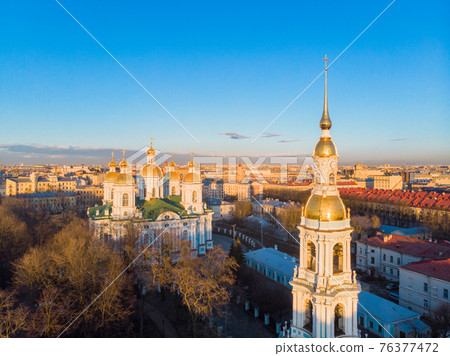 Aerial top view to St. Nicholas Naval Sea Cathedral in sunny day. Panorama of evening historical city center. Orthodox church located on banks of Kryukov and Griboyedov canal. Saint Petersburg. Russia Aerial top view to St. Nicholas Naval Sea Cathedral in sunny day. Panorama of evening historical city center. Orthodox church located on banks of Kryukov and Griboyedov canal. Saint Petersburg. Russia 76377472