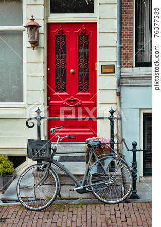 Bicycle near door of old house in Amsterdam street Bicycle near door of old house in Amsterdam street 76377588