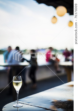 glass of champagne at modern outdoor bar at sunset 76378009