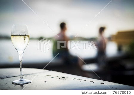 glass of champagne at modern outdoor bar at sunset 76378010