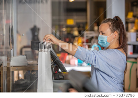 Saleswoman or shopgirl hands over the recepit or invoice by the shopping in the shop center, cloth sale concept Saleswoman or shopgirl hands over the recepit or invoice by the shopping in the shop center, cloth sale concept 76378796