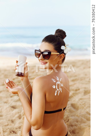 Woman Applying Sun Cream  on Tanned  Shoulder In Form Of The Sun. Sun Protection.Sun Cream. 76380412