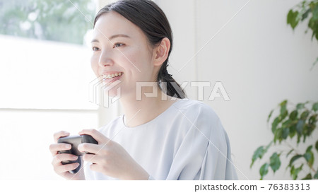 Young woman playing games at home Young woman playing games at home 76383313