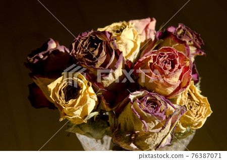 There is a bouquet of dried rose flowers. 76387071