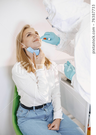 Medical worker taking a swab for corona virus Medical worker taking a swab for corona virus 76387733