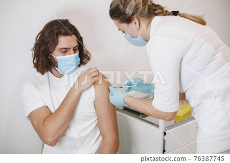 Woman doctor gives a vaccine to patients Woman doctor gives a vaccine to patients 76387745