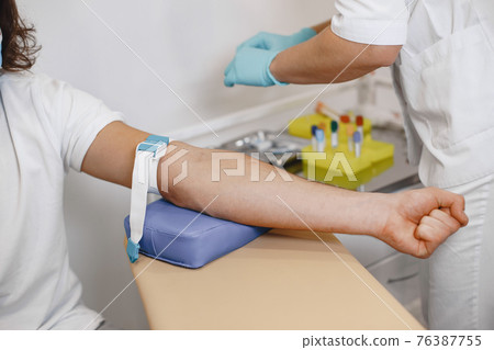 Nurse taking blood sample from patient at the doctors office Nurse taking blood sample from patient at the doctors office 76387755