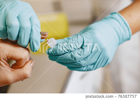 Nurse taking blood sample from patient at the doctors office Nurse taking blood sample from patient at the doctors office 76387757