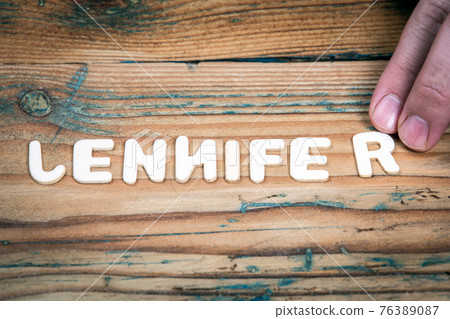 JENNIFER. Name of women and girls. White letters of the alphabet on a wooden background JENNIFER. Name of women and girls. White letters of the alphabet on a wooden background 76389087