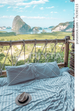 hat against Phang Nga bay background, Tourists relaxing in tropical resort at Samet Nang She, near Phuket in Southern Thailand. Southeast Asia travel and summer vacation, freelance concept 76390115