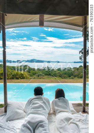 Happy Couple traveler enjoy Beautiful ocean view, Tourists relaxing in tropical luxury resort with swimming pool.Together, honeymoon, love, travel and summer vacation concept 76390183