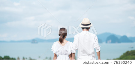 Happy couple traveler in white shirt and dress enjoy Beautiful view, Tourists with standing and relaxing over ocean. travel, together, love, summer and vacation concept Happy couple traveler in white shirt and dress enjoy Beautiful view, Tourists with standing and relaxing over ocean. travel, together, love, summer and vacation concept 76390240