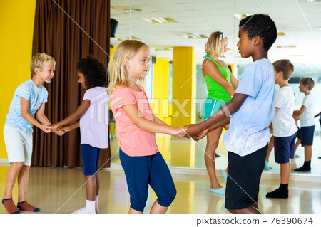 Positive little boys and girls dancing pair dance in the ballet studio Positive little boys and girls dancing pair dance in the ballet studio 76390674