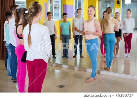 Experienced positive dance instructor teaching teenagers in choreography class Experienced positive dance instructor teaching teenagers in choreography class 76390734
