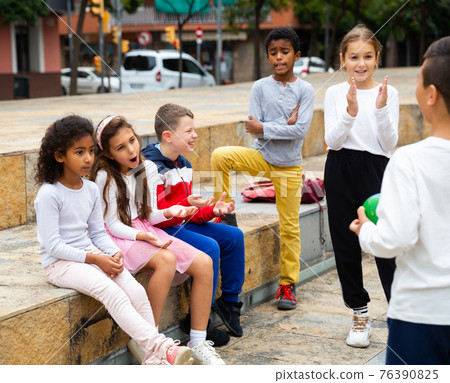 Happy tween boys and girls gathering outdoors on autumn day Happy tween boys and girls gathering outdoors on autumn day 76390825