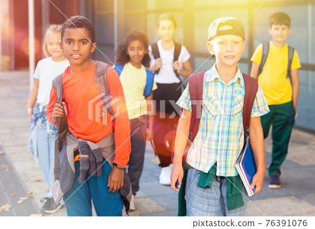 Preteen schoolchildren with rucksacks going to college Preteen schoolchildren with rucksacks going to college 76391076