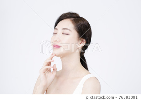 beatiful Asian woman with white sleeveless, white background shot with beauty cosmetics concept beatiful Asian woman with white sleeveless, white background shot with beauty cosmetics concept 76393091