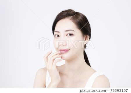 beatiful Asian woman with white sleeveless, white background shot with beauty cosmetics concept 76393197