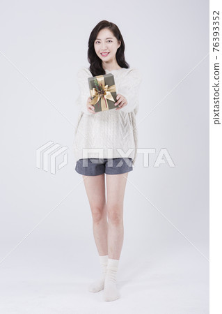 Asian female model with long hair holding gift, winter beauty concept Asian female model with long hair holding gift, winter beauty concept 76393352