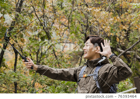 Asian handsome man trekking, climbing autumn mountain Asian handsome man trekking, climbing autumn mountain 76393464