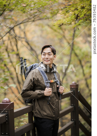 Asian handsome man trekking, climbing autumn mountain Asian handsome man trekking, climbing autumn mountain 76393482