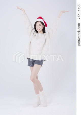Asian female model with long hair wearing Santa hat, winter Christmas beauty promotion concept Asian female model with long hair wearing Santa hat, winter Christmas beauty promotion concept 76393590