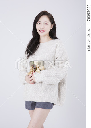 Asian female model with long hair holding gift, winter beauty concept Asian female model with long hair holding gift, winter beauty concept 76393601