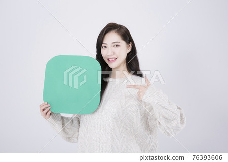 Asian female model with long hair holding copyspace poster, winter beauty promotion concept Asian female model with long hair holding copyspace poster, winter beauty promotion concept 76393606