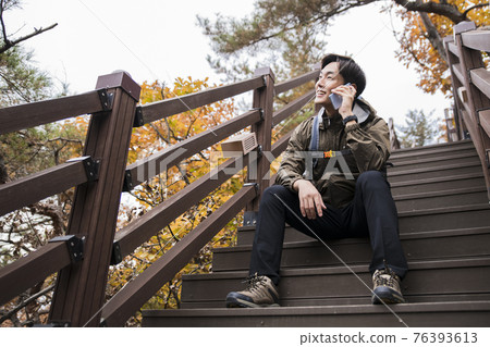 Asian handsome man trekking, climbing autumn mountain Asian handsome man trekking, climbing autumn mountain 76393613