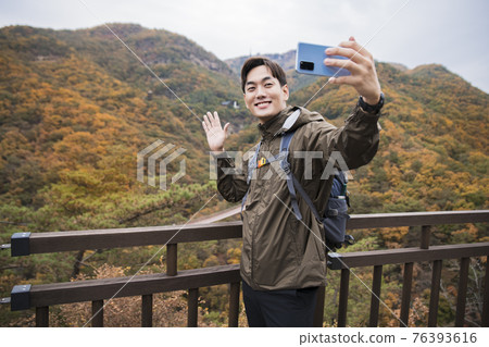 Asian handsome man trekking, climbing autumn mountain Asian handsome man trekking, climbing autumn mountain 76393616
