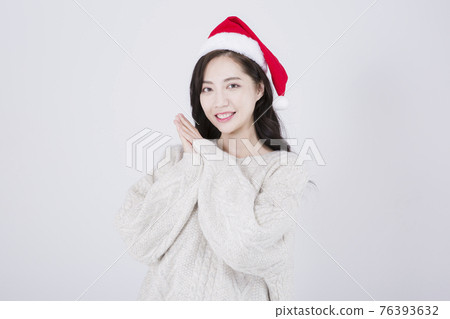 Asian female model with long hair wearing Santa hat, winter Christmas beauty promotion concept Asian female model with long hair wearing Santa hat, winter Christmas beauty promotion concept 76393632